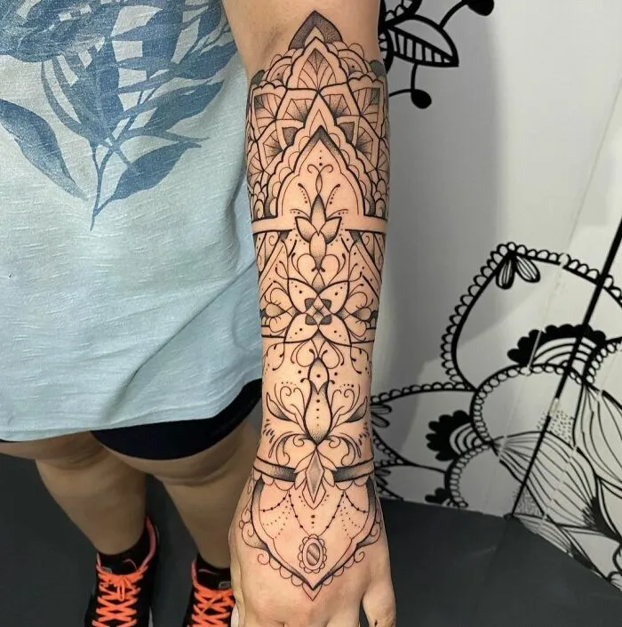 Geometric tattoo design covering forearm, showcasing intricate shapes, forms, and creativity in black ink.