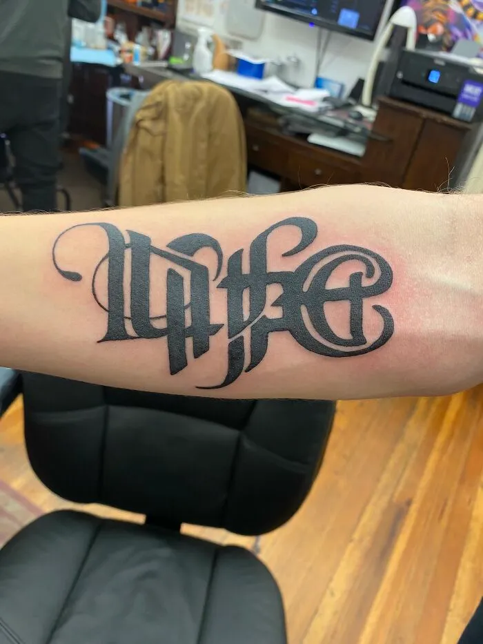 Tattoo with stylized text "Life" on an arm in a tattoo studio, showcasing cringe tattoo style.