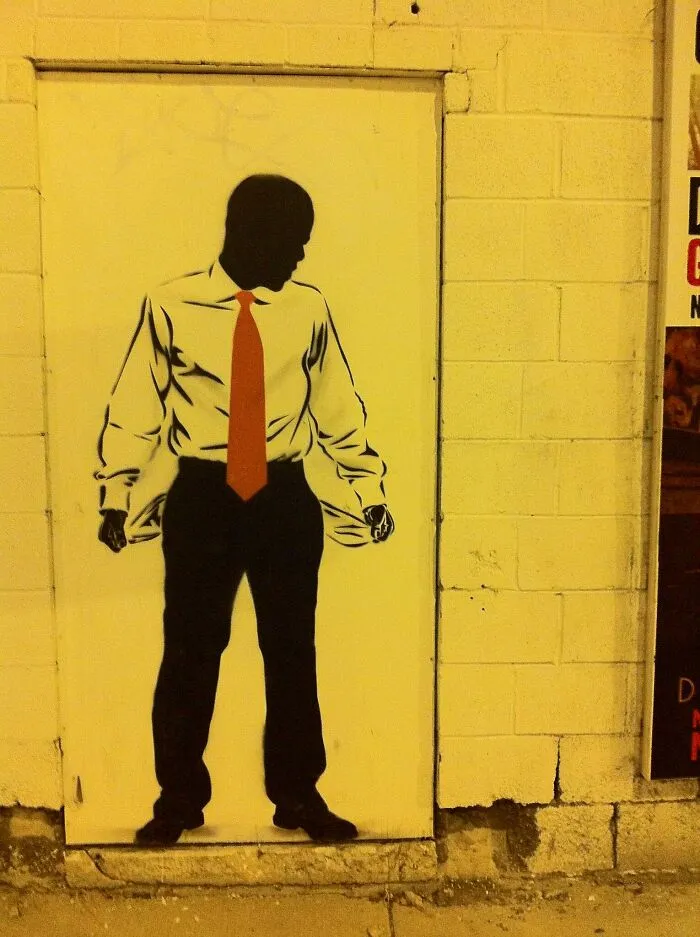 Street art of a man in a shirt and red tie showing empty pockets, symbolizing things the poor know but the rich don't.