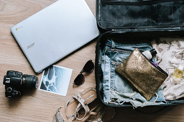 Camera, computer and luggage with travel stuff inside