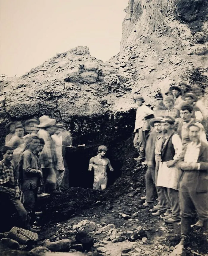 1894. Arqueólogos y trabajadores posan frente a la estatua de Antinoo, casi perfectamente conservada y aún en pie, descubierta cerca del templo de Apolo en el santuario de Delfos, Grecia