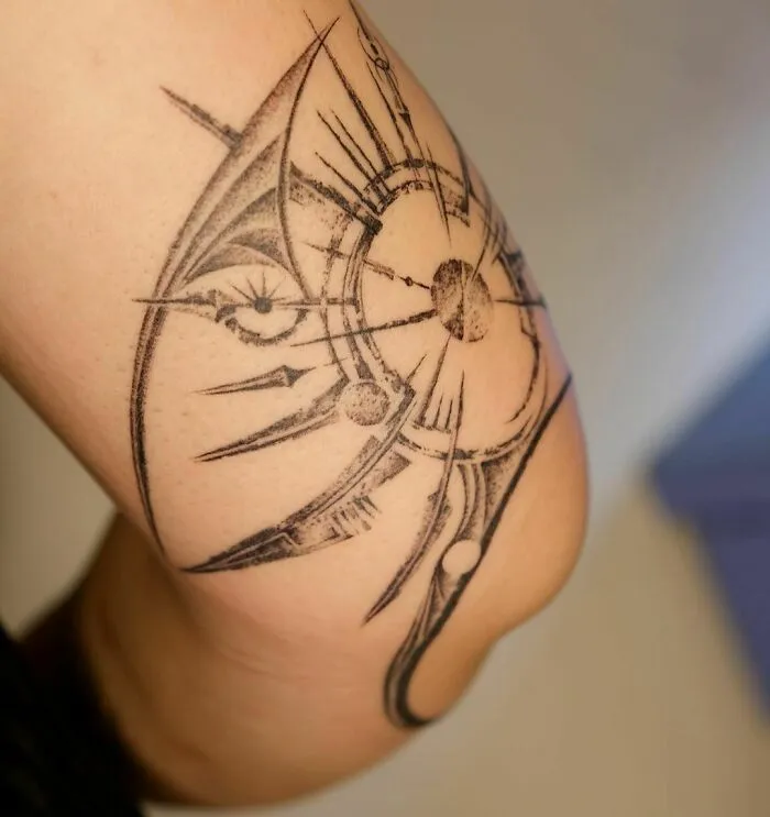 Geometric tattoo design on arm featuring intricate shapes, forms, and creative patterns.