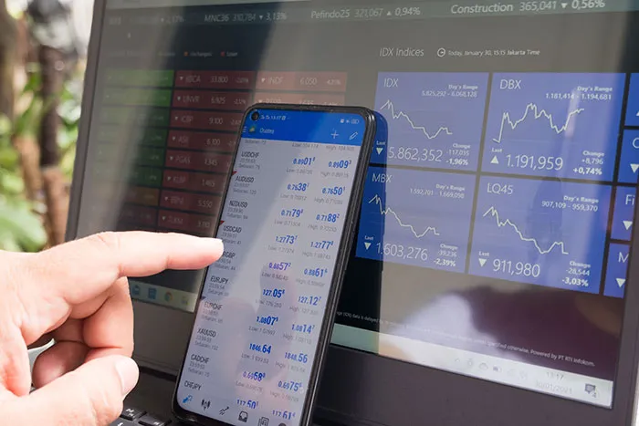 Person pointing at stocks in phone