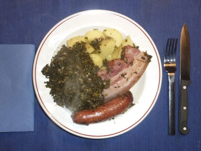 A Typical Northern German Dish: Green Cabbage With Potatos Plus Pork Belly And A Sausage, Both Smoked And Cooked