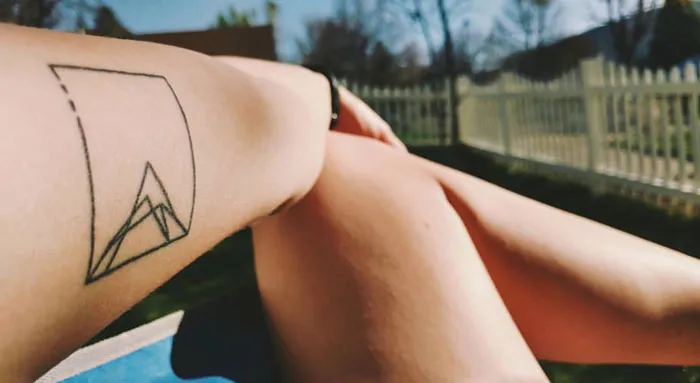 Geometric tattoo on arm featuring shapes and forms, showcasing creativity.