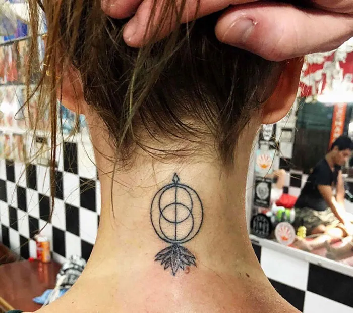Geometric tattoo on the neck featuring circular shapes and a leaf pattern, showcasing creativity in design.