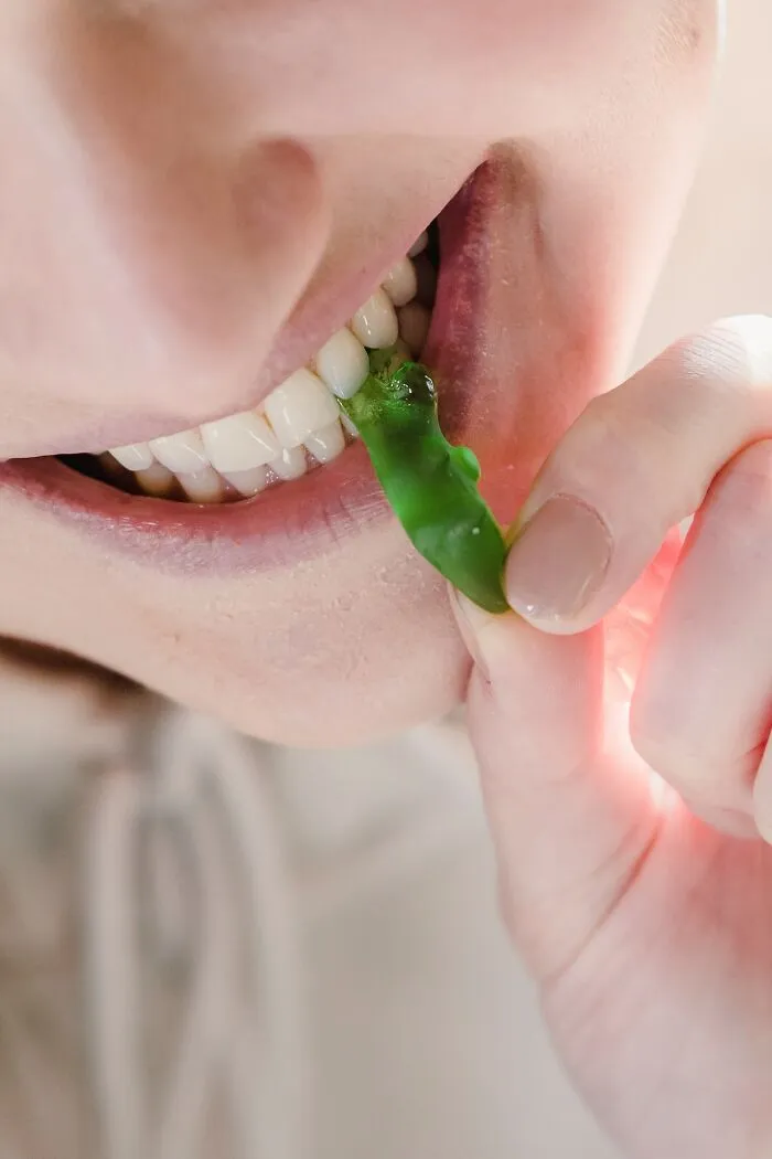 Close-up of person biting a green chili pepper illustrating things the poor know but the rich don’t perspective.