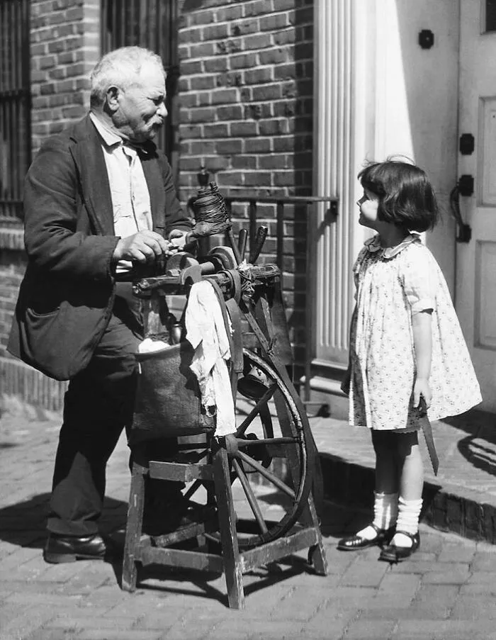 Afilador de cuchillos ambulante con un cliente. Estados Unidos, principios de 1910