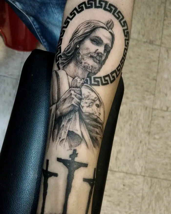 "Realistic San Juditas tattoo showcasing intricate religious detailing on forearm."