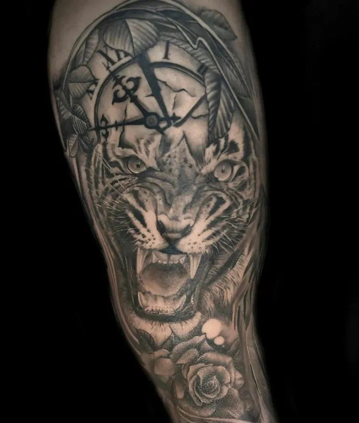 A realistic tattoo featuring a tiger, clock, and rose with intricate detailing.