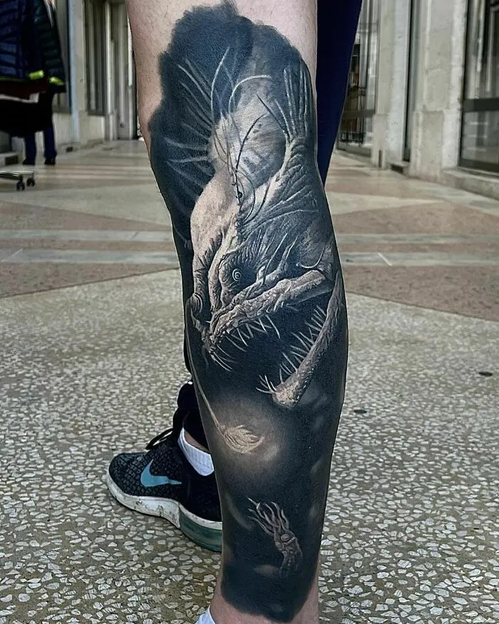 Realistic deep sea anglerfish tattoo on leg with intricate detailing.