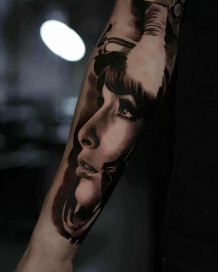 Realistic tattoo depicting a girl's profile looking up, showcasing exquisite detail and shading on forearm.