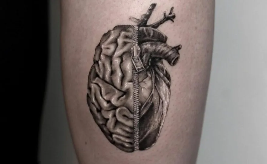 Realistic tattoo of a brain and heart zipped together with intricate detailing.