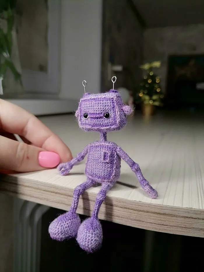 Acabo de terminar mi pequeño robot. Tiene un color inusual. Está sobre una estructura de alambre. Puede doblar brazos y piernas