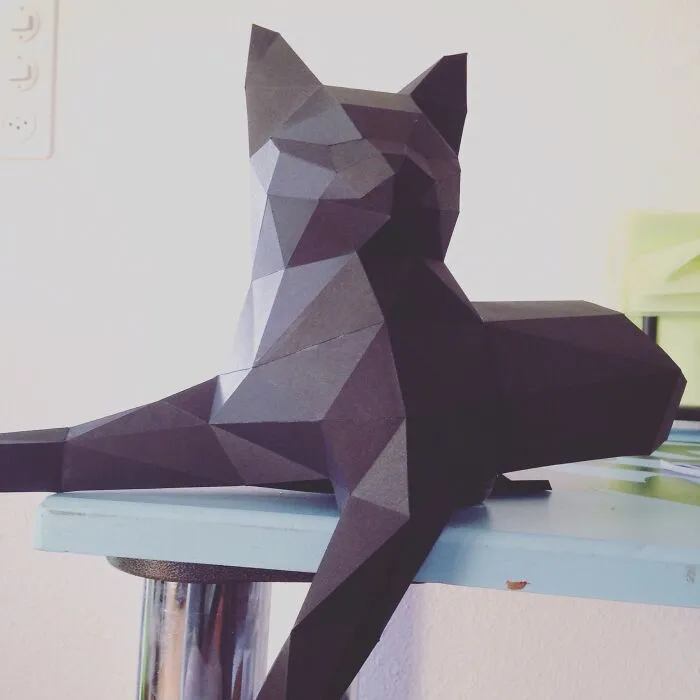 a black cat made out of a paper
