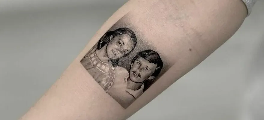 Realistic forearm tattoo of mother and father portraits showcasing detailed artistry.