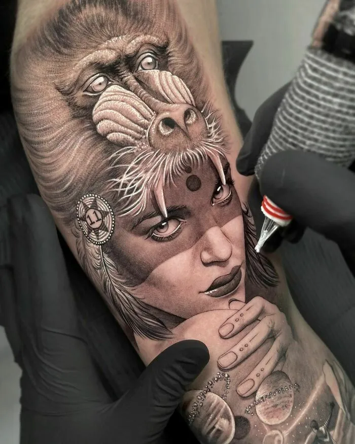 Amazingly detailed tattoo of a woman with a baboon mask on her forehead, showcasing realistic artistry.