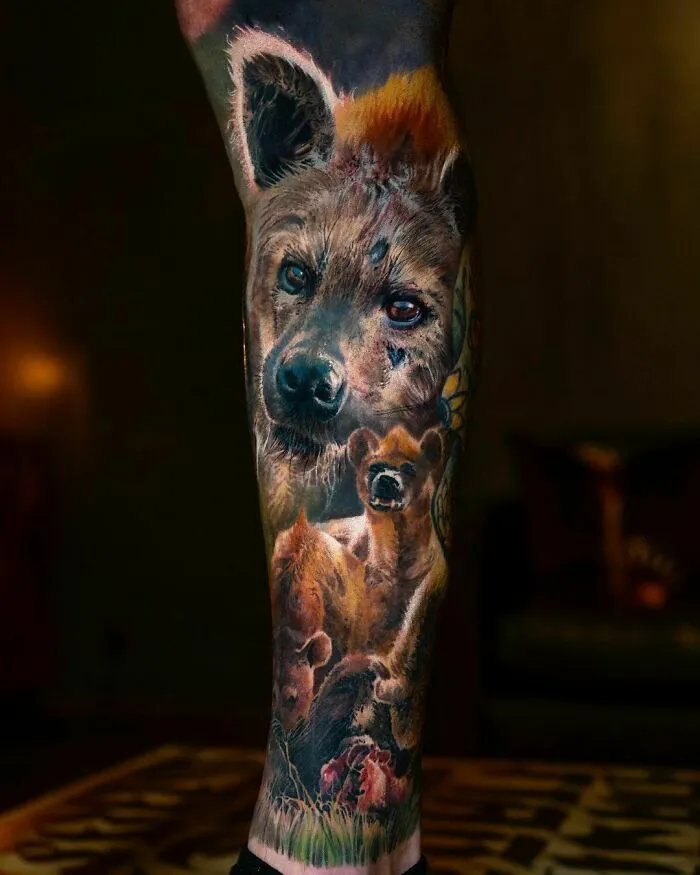 Realistic hyena-themed leg tattoo showcasing detailed artistry and vivid imagery.