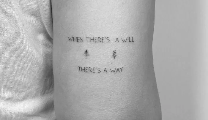 "Creative word tattoo saying 'When there's a will, there's a way' with minimalist tree symbols on an arm."
