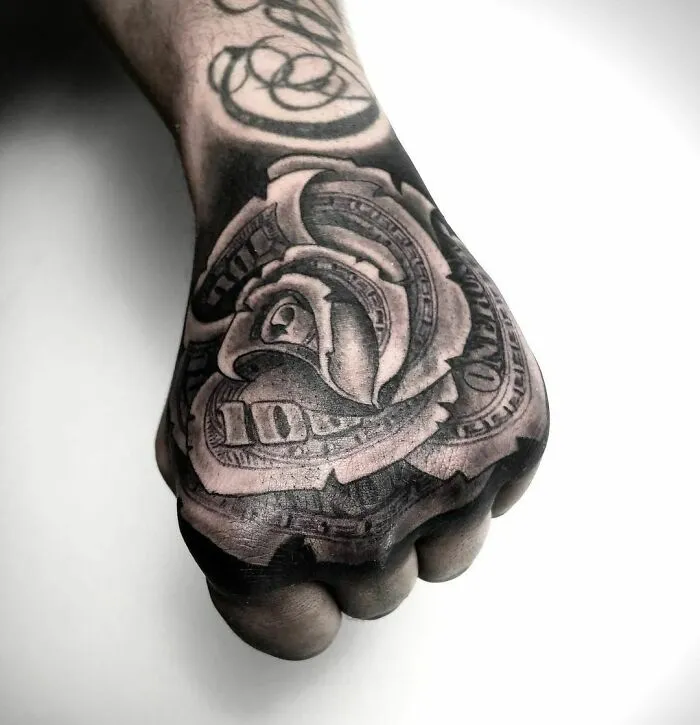 Hand tattoo featuring a detailed dollar rose design, showcasing super realistic art.