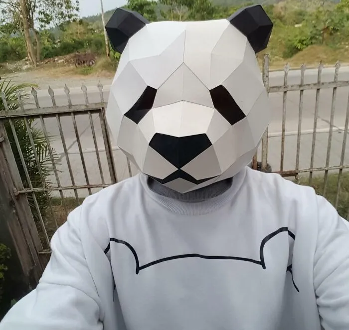 a panda head origami on the head of a man
