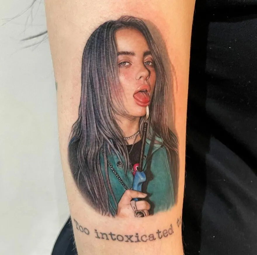 Realistic tattoo of a colorful girl portrait with tongue out and lit electric stove lighter.
