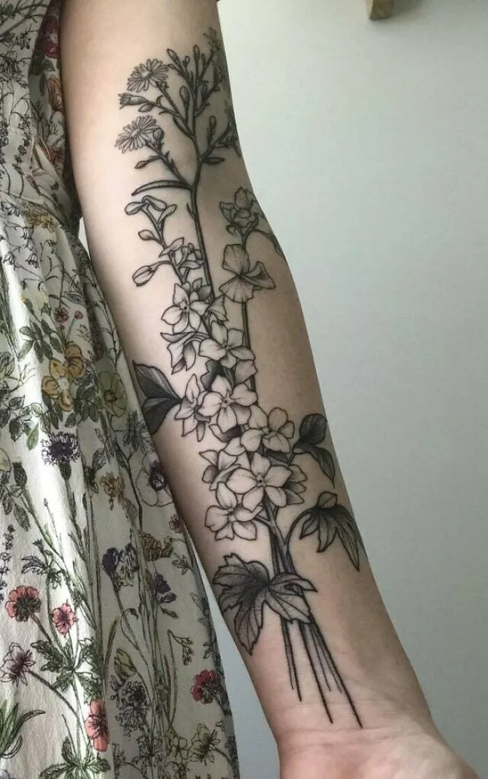 Elegant flower tattoo design on a forearm, showcasing detailed floral patterns.