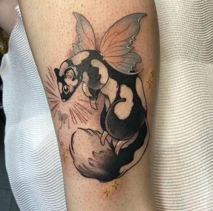 Realistic animal tattoo of a sugar glider with wings, showcasing simplicity in design on an arm.