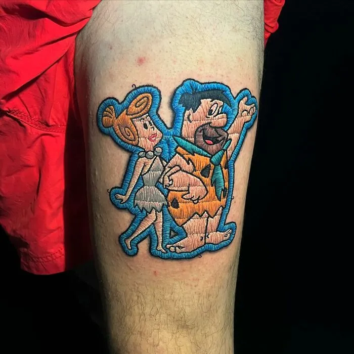 Tattoo of cartoon characters on leg, showcasing Eduardo Lozano's new dimension in tattooing.