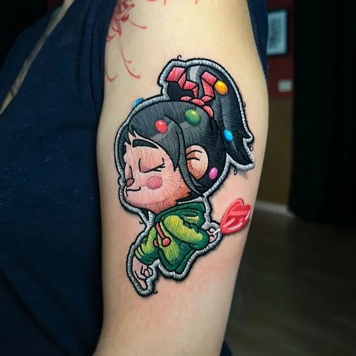 3D effect tattoo in vibrant colors on an arm, showcasing a playful cartoon style by Eduardo Lozano.