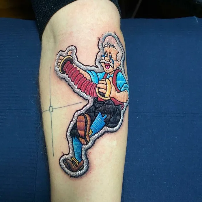 Tattoo by Eduardo Lozano featuring a 3D cartoon character on a forearm, showcasing unique tattooing dimensions.