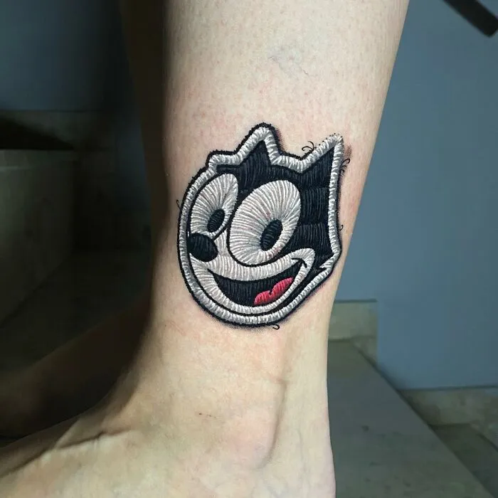 Tattoo resembling a cat character by Eduardo Lozano, showcasing a new dimension in his tattoo art style.