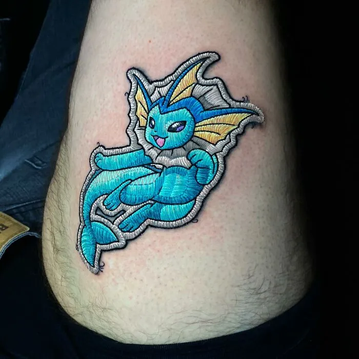 Embroidered-style tattoo featuring a vibrant blue water creature, showcasing Eduardo Lozano's innovative tattooing technique.
