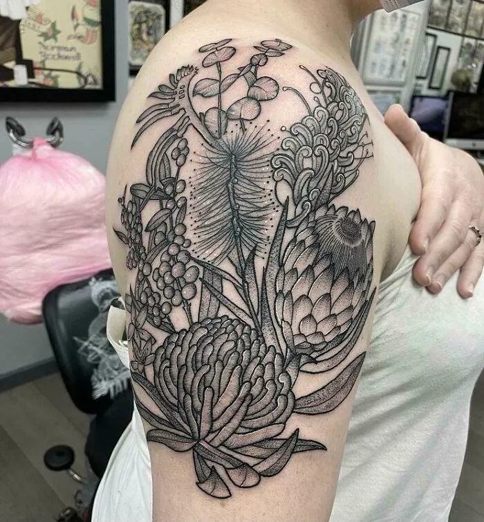 Elegant flower tattoo on shoulder, showcasing intricate botanical details that radiate beauty.