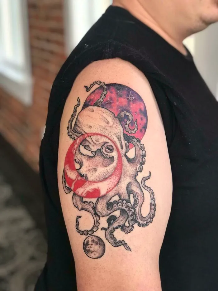 Octopus and moon-themed space tattoo on upper arm, vibrant and detailed design for astrology fans.
