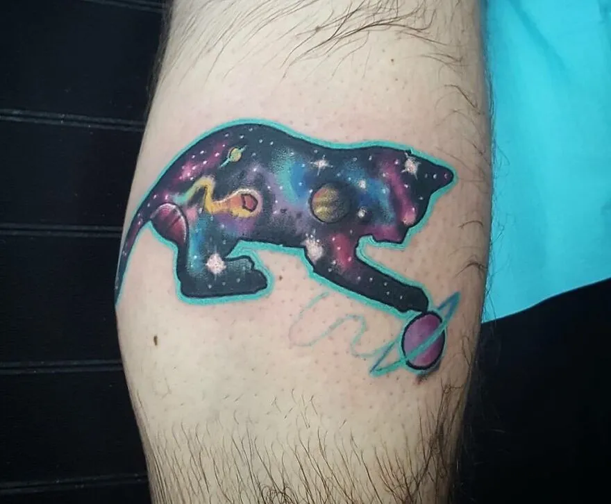 Space tattoo of a galaxy-themed animal with planets and stars on forearm.
