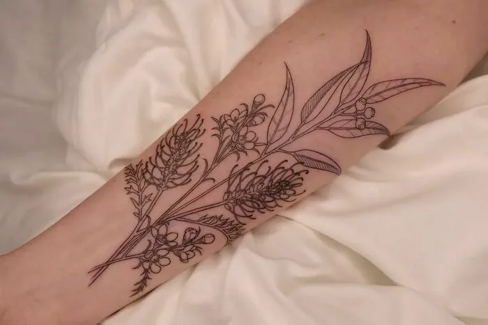 Elegant flower tattoo on forearm, showcasing detailed botanical design.