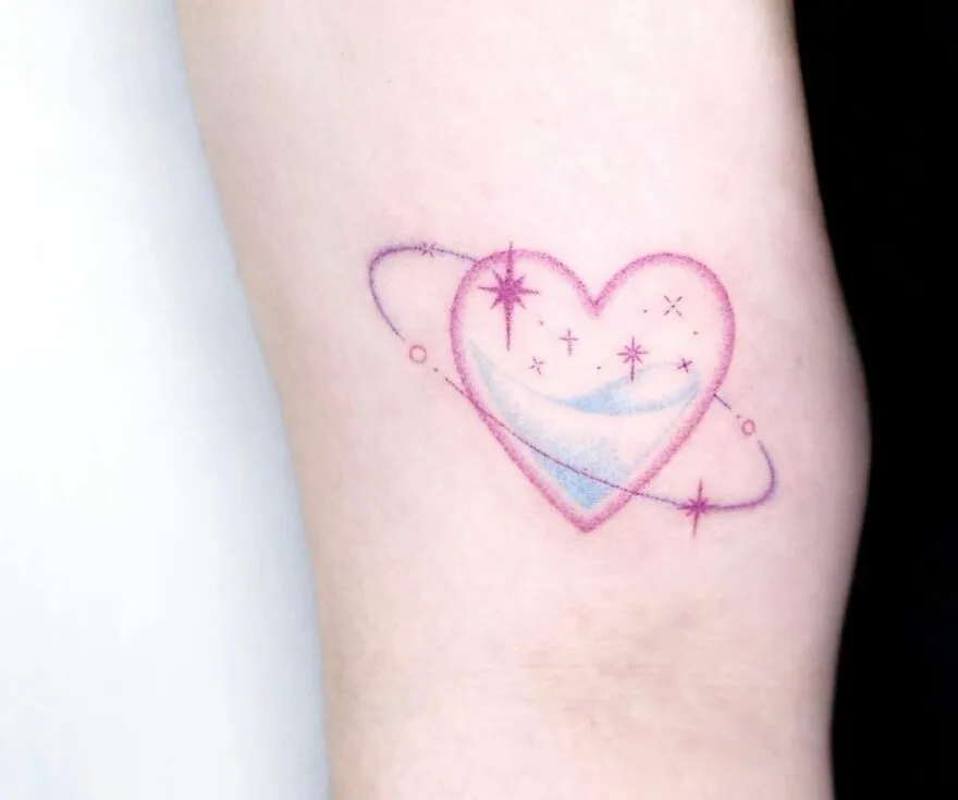 Heart-shaped space tattoo with stars and rings for astrology fans.