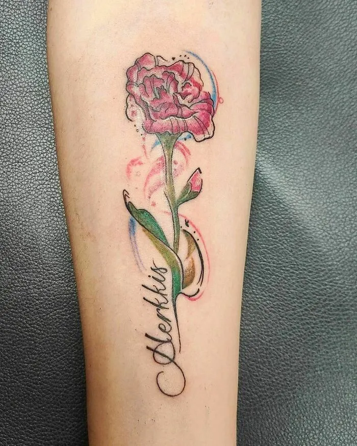 Elegant flower tattoo with vibrant colors on forearm, showcasing beauty and artistry.