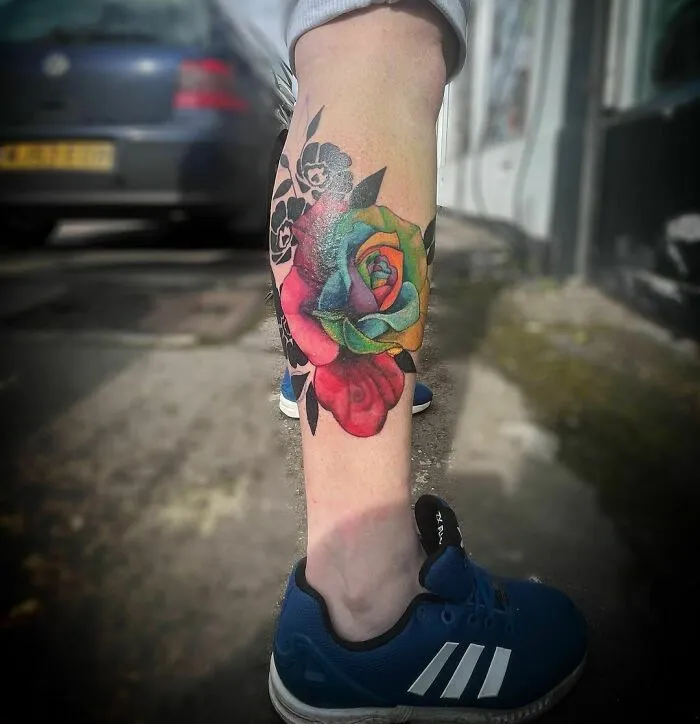 Colorful flower tattoo on a leg, showcasing elegance and beauty.