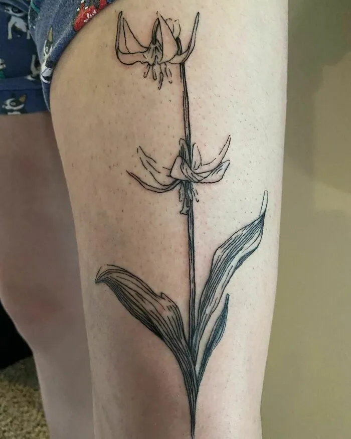 Elegant flower tattoo on thigh showcasing beauty and grace.