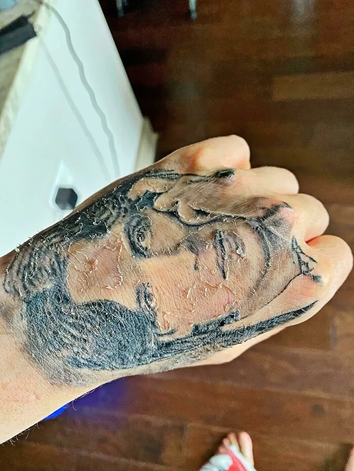 Tattoo on a hand blending seamlessly with the skin's texture, creating a striking accidental match.