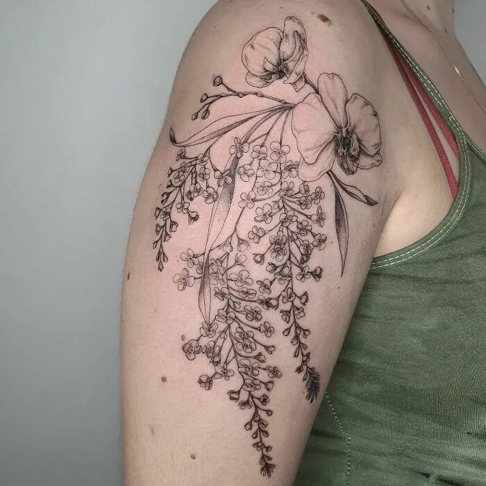 Elegant flower tattoo on arm with intricate floral design.