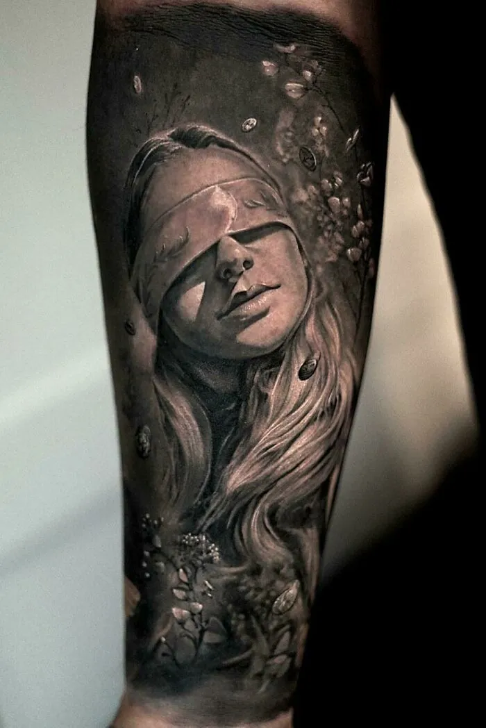 Super realistic tattoo of a young woman with eyes covered, showcasing intricate detailing.