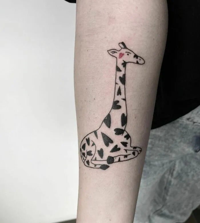 Giraffe tattoo on an arm with heart-shaped spots, celebrating the animal kingdom.