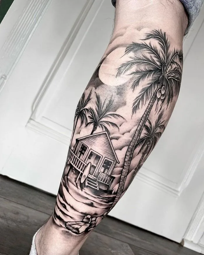 Calf tattoo featuring a tropical beach scene with palm trees and a house under the moonlight.