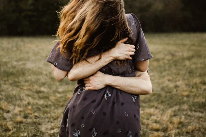 Couple hugging in field