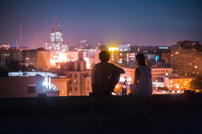 A couple on roof sitting and watching the night view