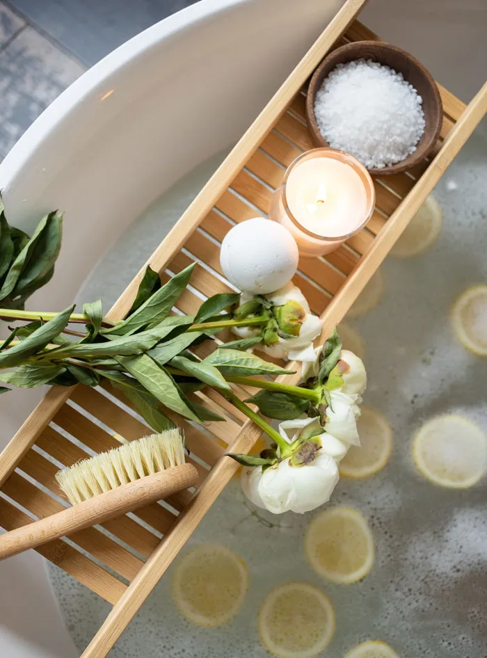 Spa bath with flowers, salt, and lit candle