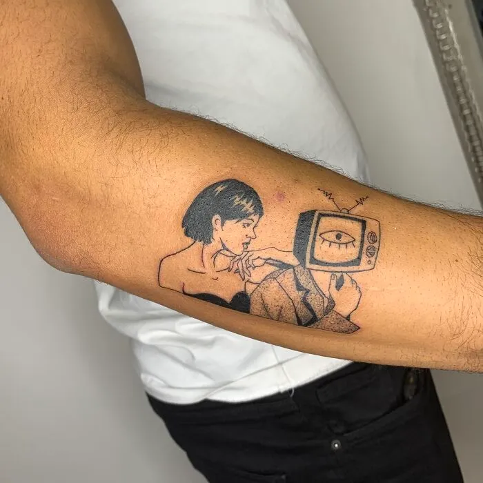Tattoo illustration on arm depicting a person with a vintage TV head and a woman looking at them.